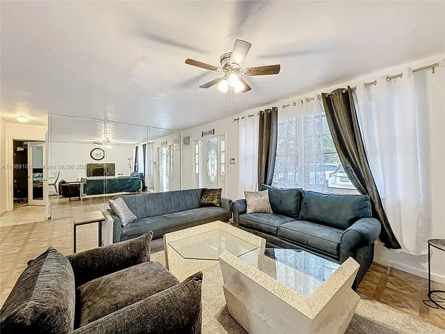 a living room with furniture ceiling fan and a rug