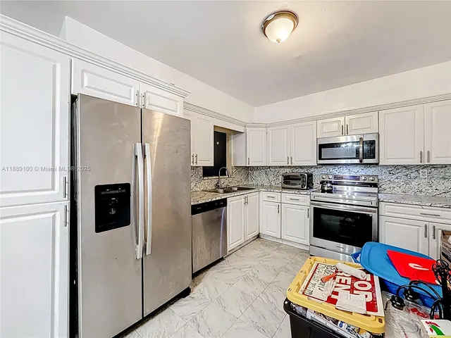 a kitchen with stainless steel appliances a stove a refrigerator and a refrigerator