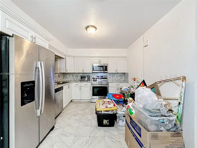 a kitchen with appliances a sink and cabinets