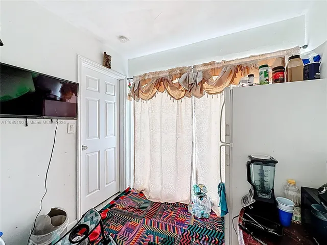 a bedroom with a refrigerator and a bed