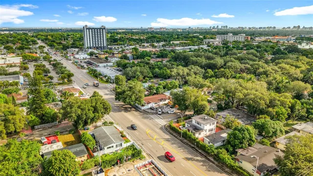 an aerial view of residential houses with outdoor space and trees