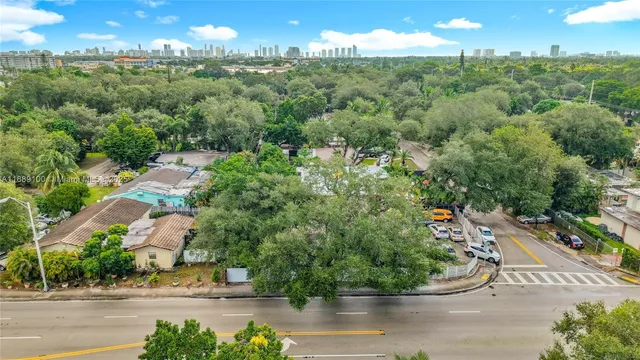 an aerial view of residential houses with outdoor space and trees