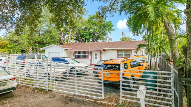 a front view of a house with cars parked