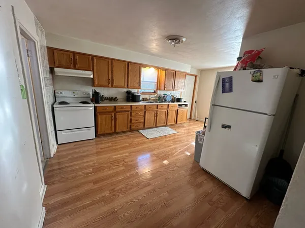 a kitchen with a refrigerator and a stove top oven