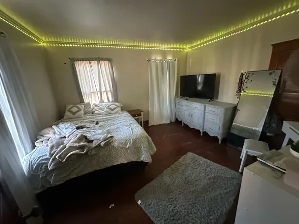 a bedroom with a bed and a flat screen tv