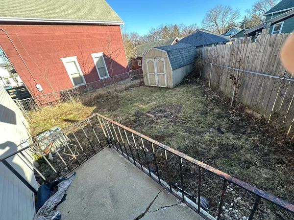 a view of a backyard with wooden fence
