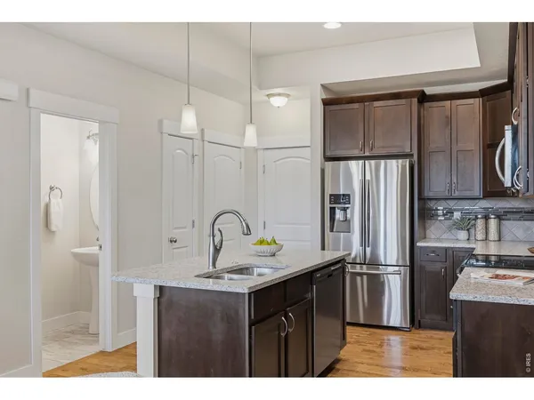 a kitchen with stainless steel appliances granite countertop a sink refrigerator and cabinets