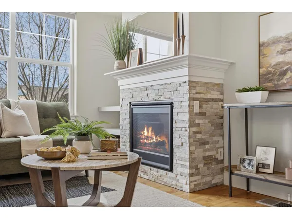 a living room with furniture a fireplace and a potted plant