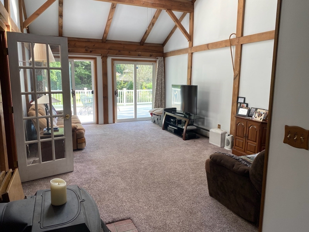 209 Gaffney Road Oakham, MA 01068 - Photo 10 of 42 a living room with furniture a flat screen tv and a large window