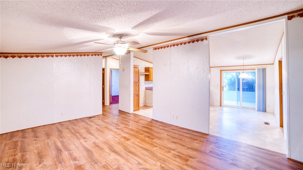 6063 Rudd Road Ashtabula, OH 44004 - Photo 2 of 17 Living room with a textured ceiling, light wood-type flooring, and a ceiling fan