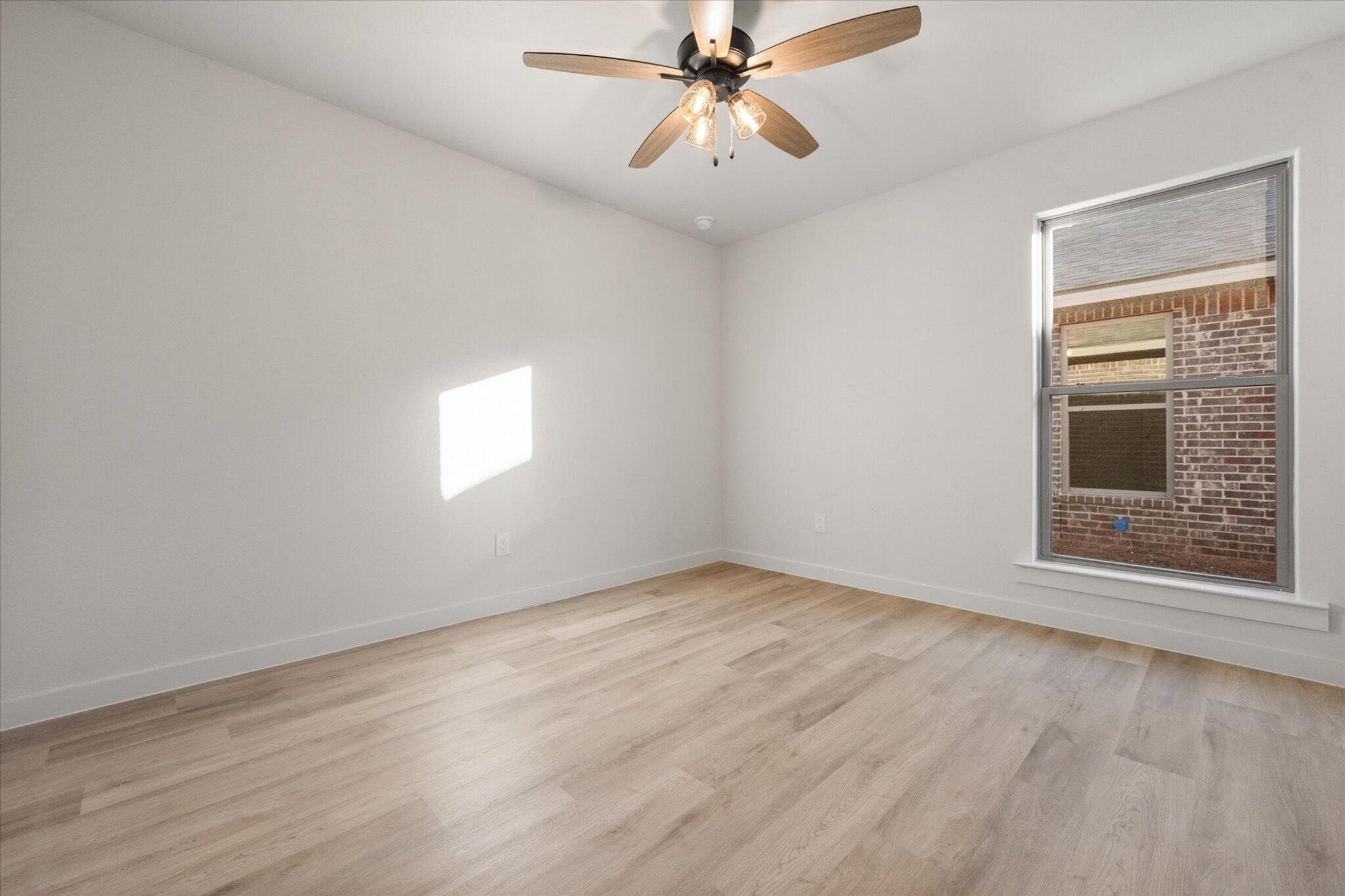 5309 Remington Avenue Lubbock, TX 79407 - Photo 18 of 22 a view of an empty room with wooden floor and a window