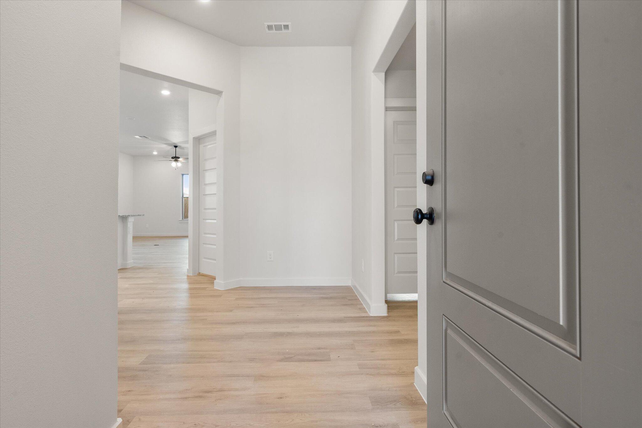 5309 Remington Avenue Lubbock, TX 79407 - Photo 2 of 22 a view of a hallway with wooden floor and a bathroom