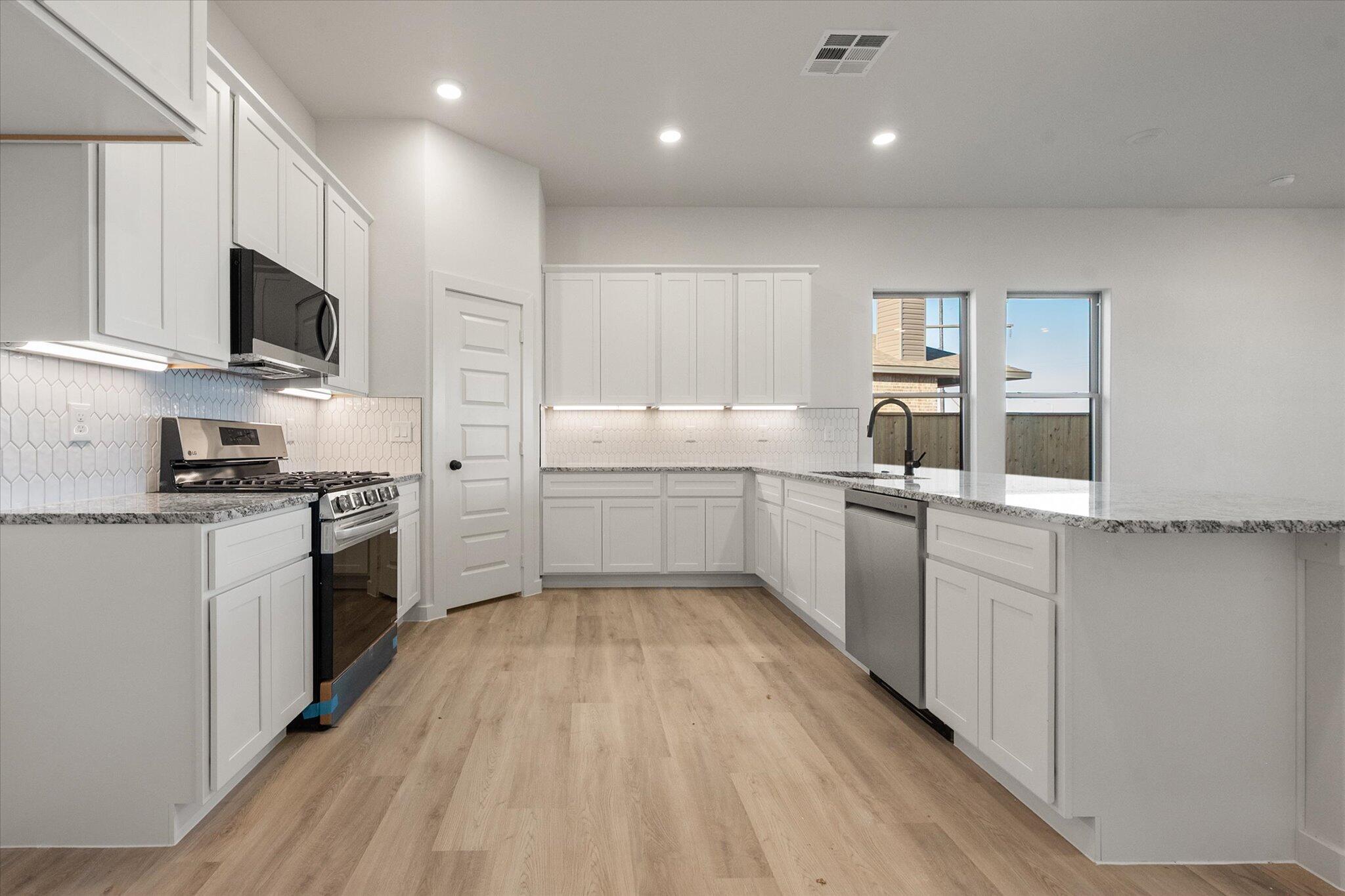5309 Remington Avenue Lubbock, TX 79407 - Photo 4 of 22 a kitchen with white cabinets appliances and sink