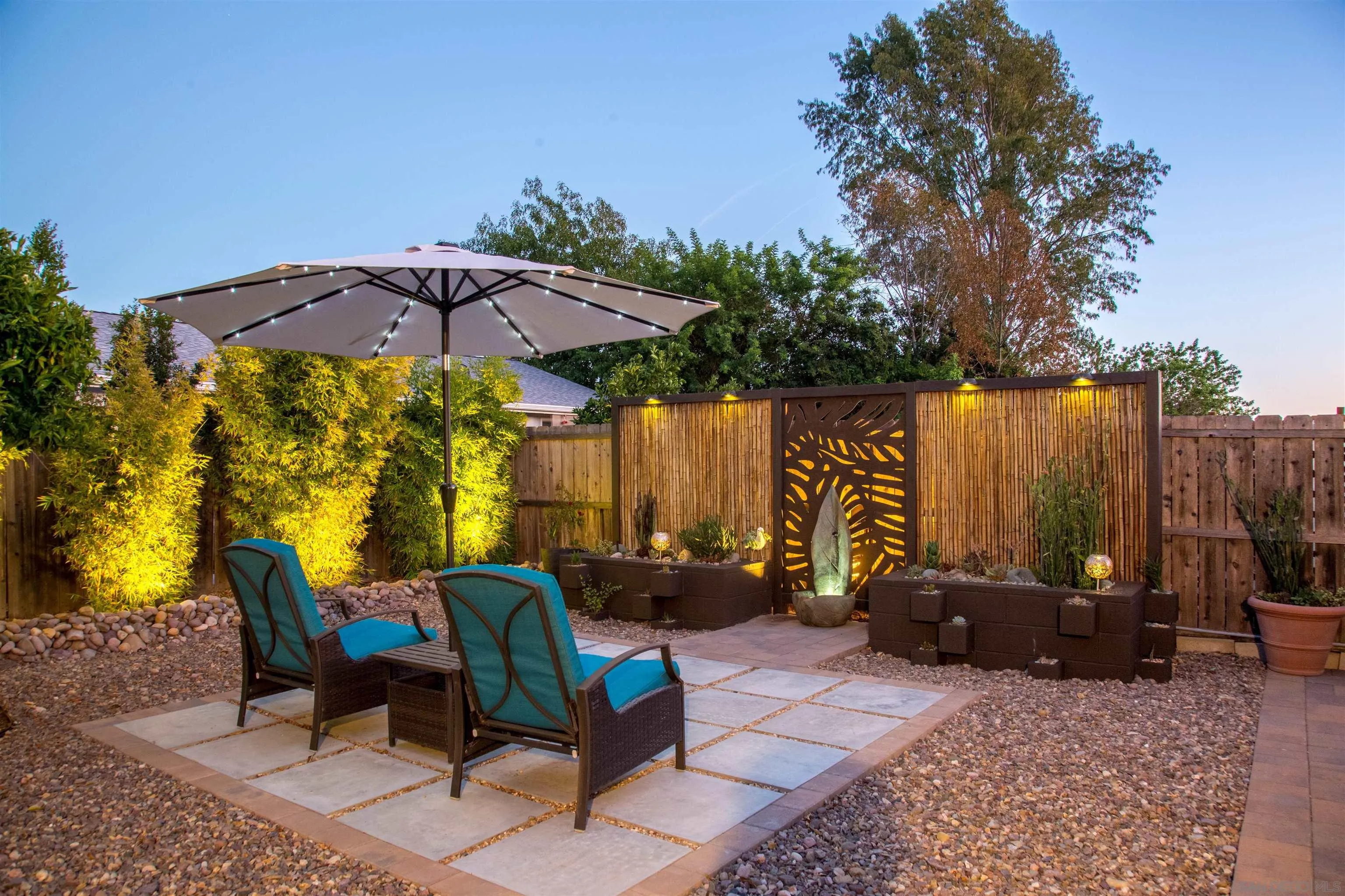 13515 Utopia Road Poway, CA 92064 - Photo 23 of 36 a view of a patio with table and chairs under an umbrella with a small yard
