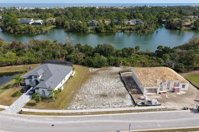 an aerial view of a house with a yard and lake view