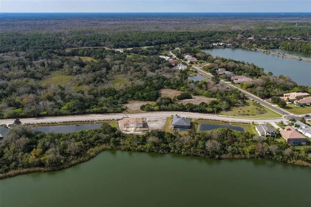 an aerial view of lake and residential houses with outdoor space
