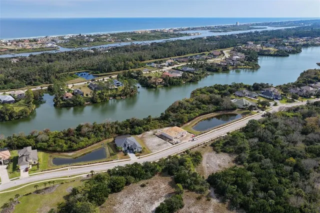 an aerial view of residential houses with outdoor space and lake view