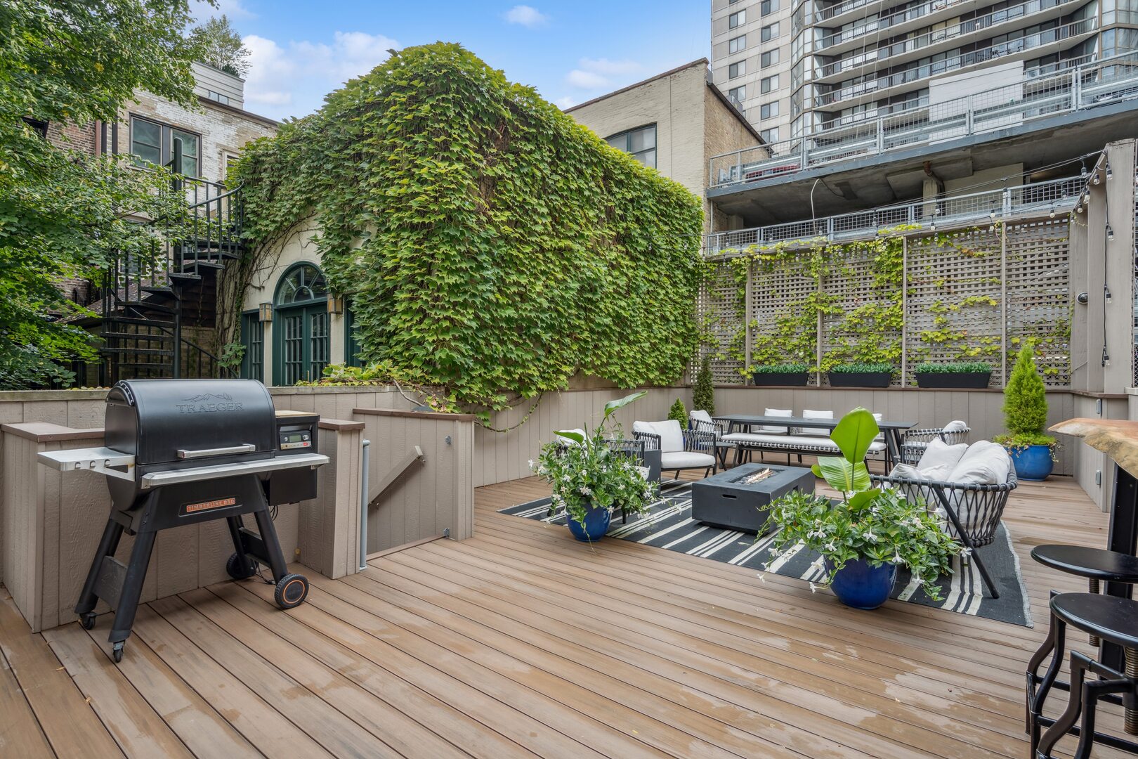 24 West Chestnut Street Chicago, IL 60610 - Photo 31 of 38 a view of a deck with table and chairs potted plants with wooden floor and fence