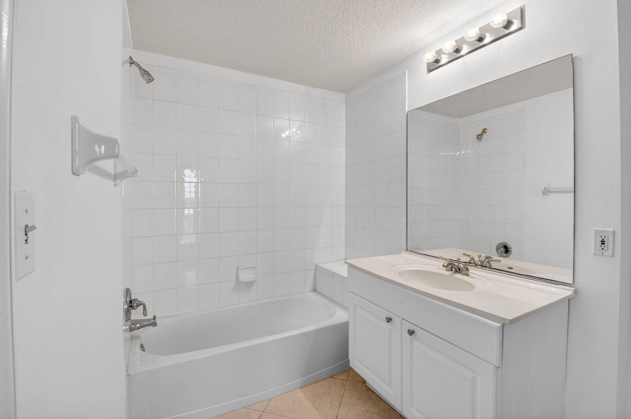 22715 Camino Del Mar, Unit 61 Boca Raton, FL 33433 - Photo 15 of 39 a bathroom with a tub a sink and mirror