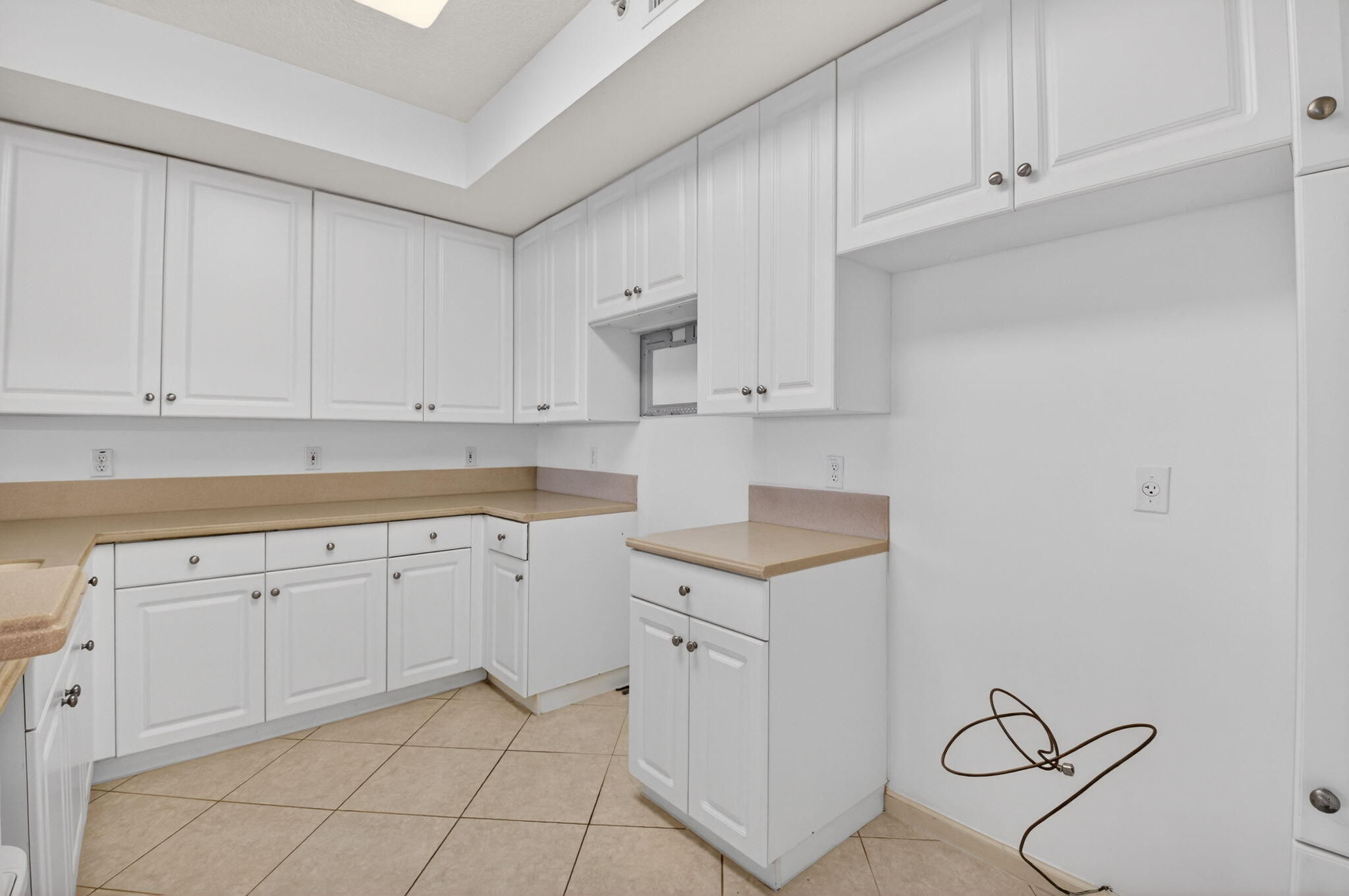 22715 Camino Del Mar, Unit 61 Boca Raton, FL 33433 - Photo 23 of 39 a kitchen with white cabinets