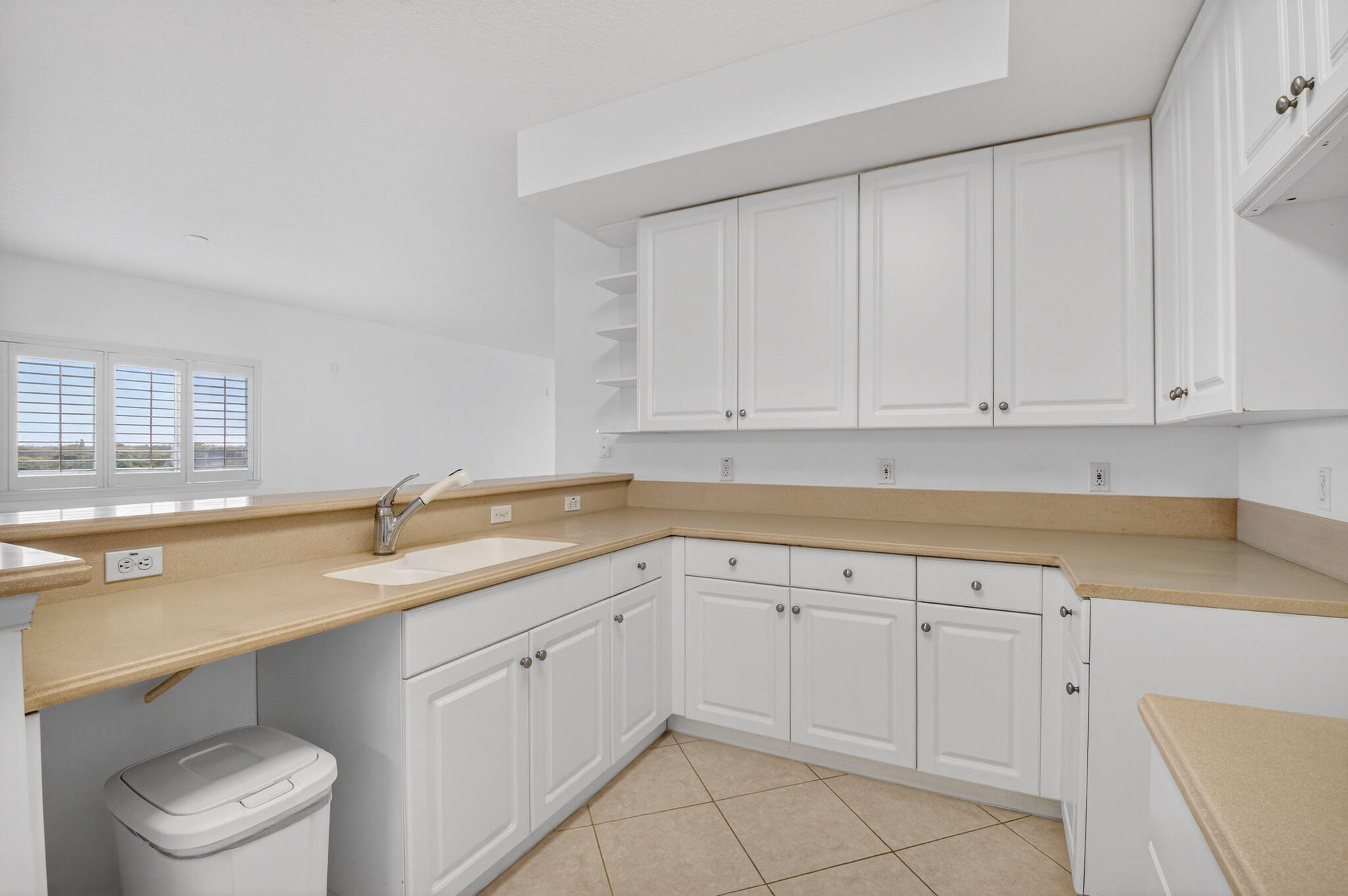 22715 Camino Del Mar, Unit 61 Boca Raton, FL 33433 - Photo 25 of 39 a kitchen with white cabinets appliances a sink and a window