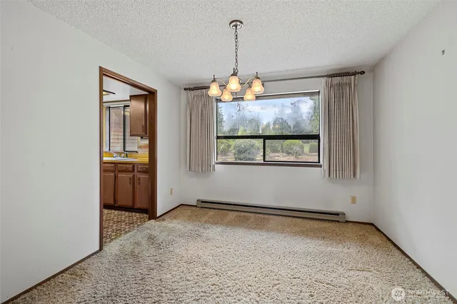 a view of a livingroom with an empty space and a window