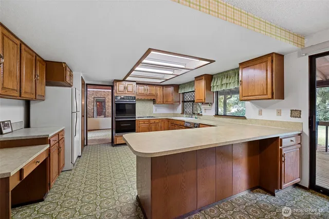 a kitchen with stainless steel appliances granite countertop a refrigerator and a sink