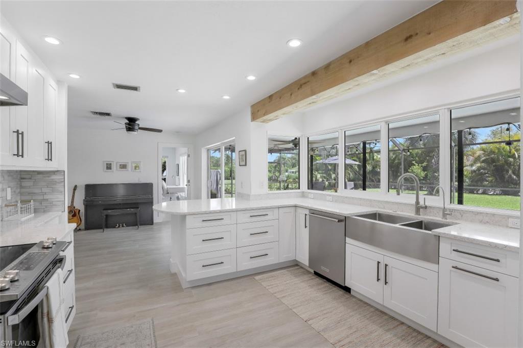 1010 Nottingham Drive Naples, FL 34109 - Photo 7 of 28 a large white kitchen with granite countertop a stove top oven a sink and dishwasher