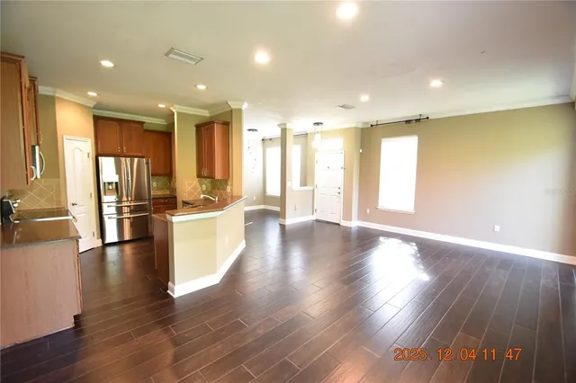 a view of kitchen with kitchen island wooden floor and refrigerator