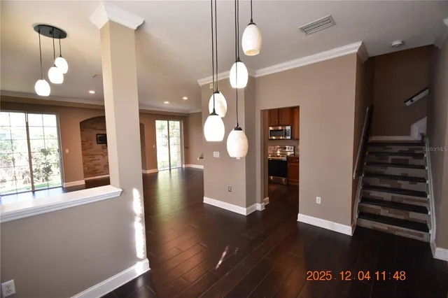 a view of a hallway with wooden floor and stairs