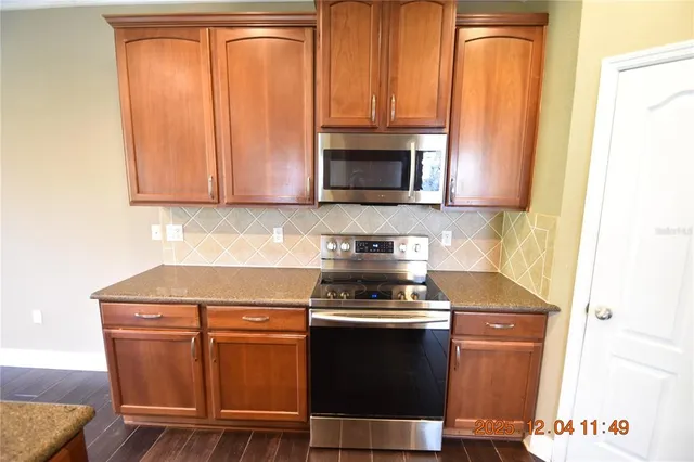 a kitchen with stainless steel appliances granite countertop a sink stove and cabinets