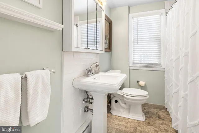 a bathroom with a sink toilet and a mirror