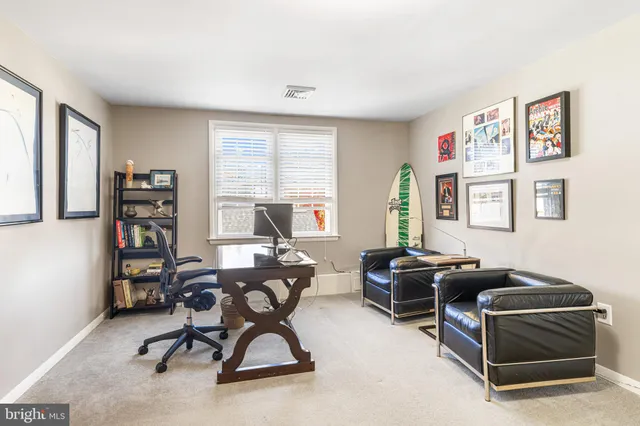a view of a workspace with furniture and a window