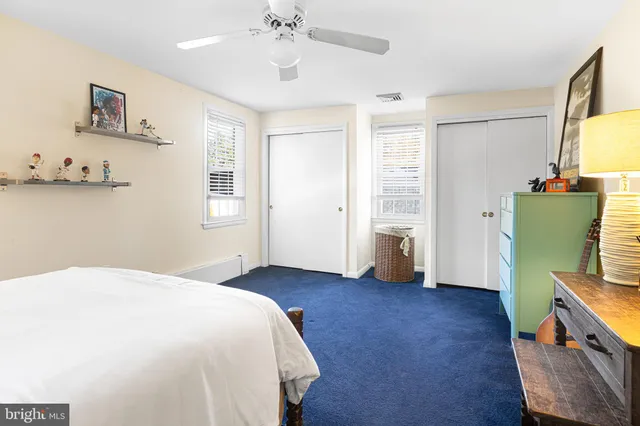 a spacious bedroom with a bed and wooden floor