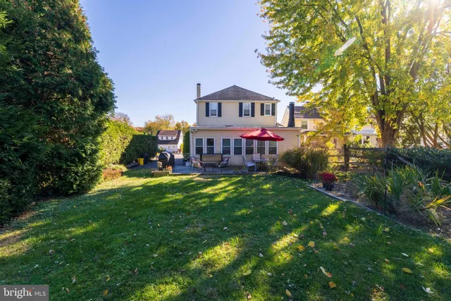 a view of house with garden and tall trees