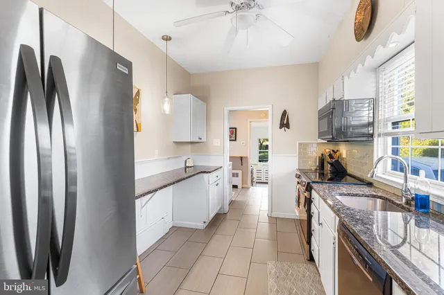 a kitchen with stainless steel appliances granite countertop a refrigerator a stove and a sink