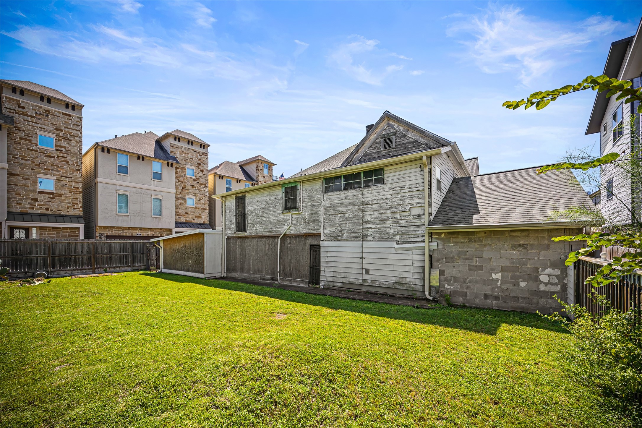 1214 Edwards Street Houston, TX 77007 - Photo 31 of 34 Charming fixer-upper with spacious backyard, surrounded by modern multi-story homes. Ideal for renovation and potential expansion.
