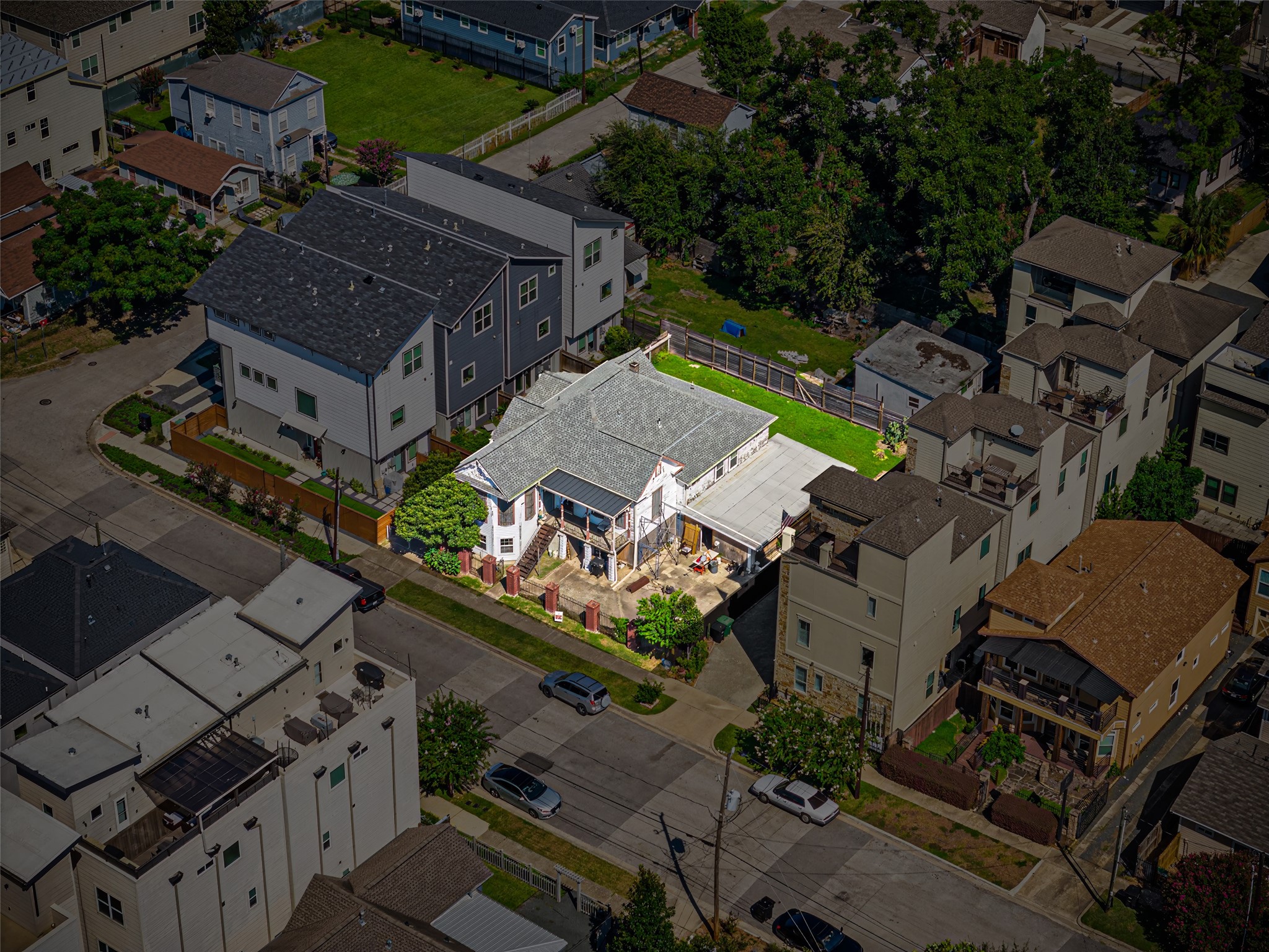 1214 Edwards Street Houston, TX 77007 - Photo 33 of 34 This aerial photo showcases a charming single-story home with a spacious yard, set in a residential neighborhood. It's surrounded by modern multi-story buildings and features a driveway and a well-maintained lawn, offering both privacy and convenience.