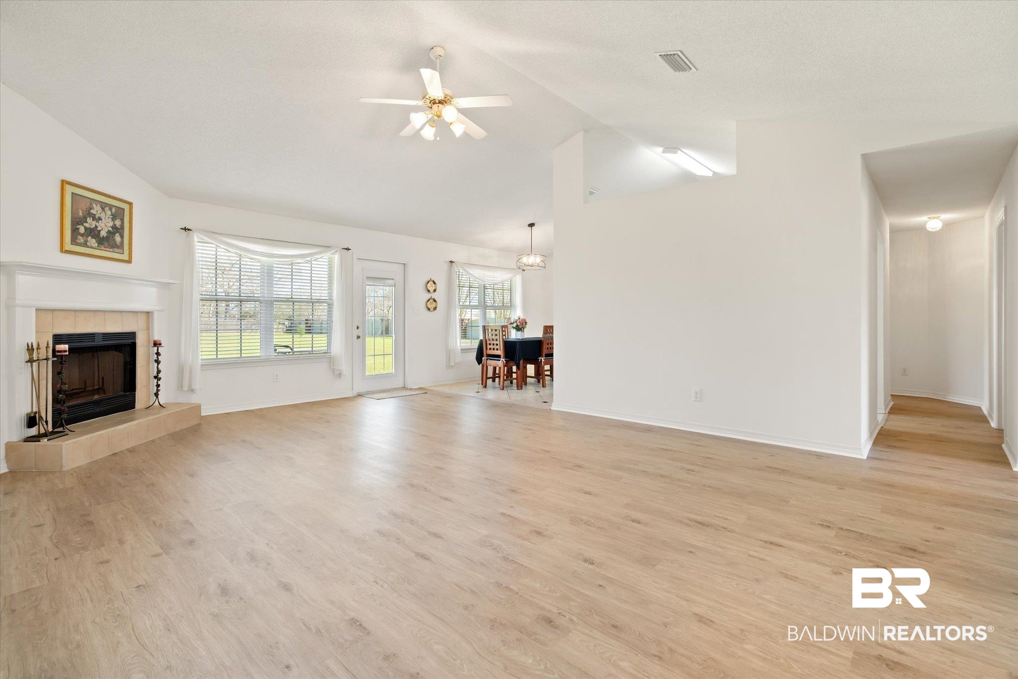 12520 Hunters Chase Foley, AL 36535 - Photo 17 of 32 Unfurnished living room with visible vents, lofted ceiling, and light wood-style floors