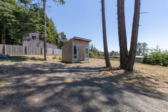 a view of a house with backyard and a tree