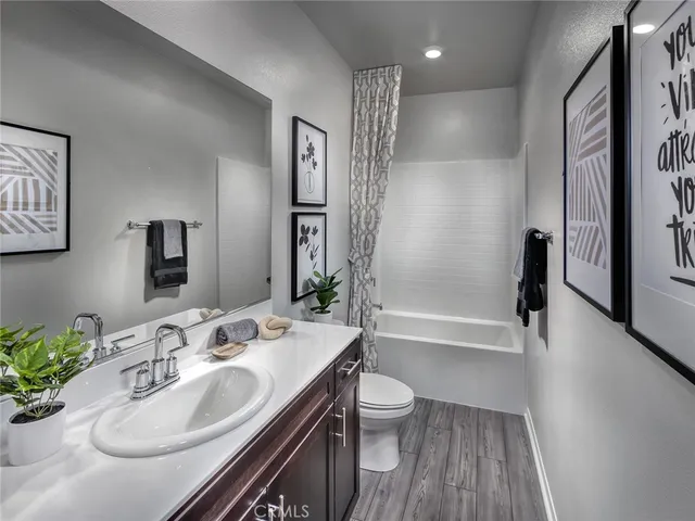 a bathroom with a sink a toilet and a large mirror