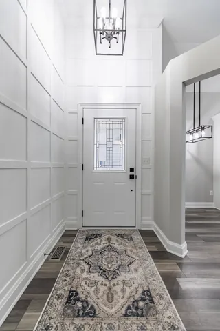 a view of a hallway with entryway wooden floor and stairs