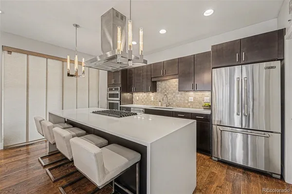 a kitchen with kitchen island a sink stove and refrigerator