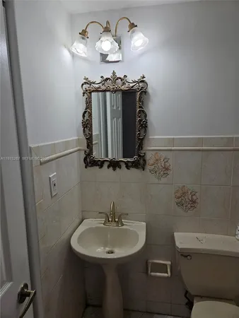 a bathroom with a sink a toilet and mirror