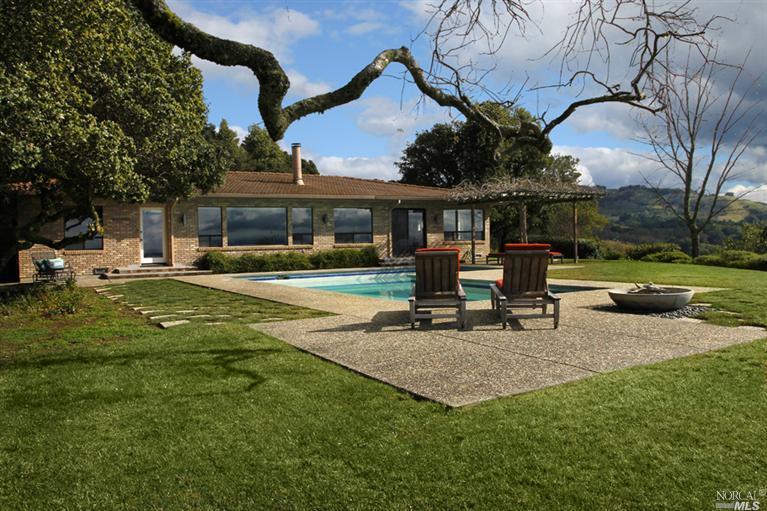a view of a house with backyard and sitting area