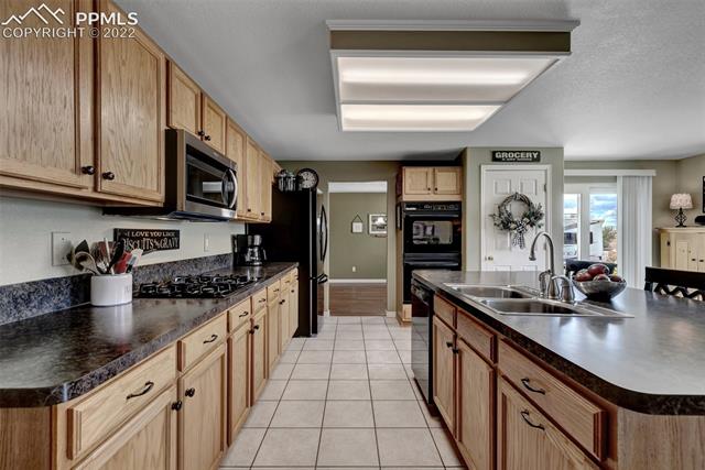 8460 Tibbs Road Peyton, CO 80831 - Photo 10 of 37 Kitchen with view into Formal Dining