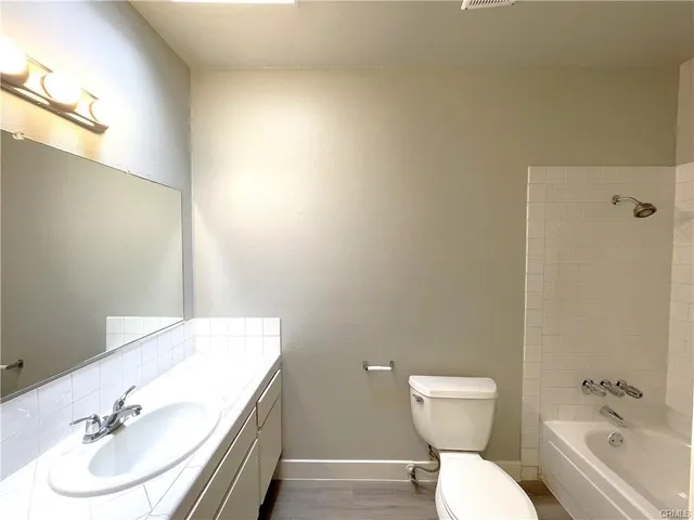 a white toilet sitting next to a bath tub