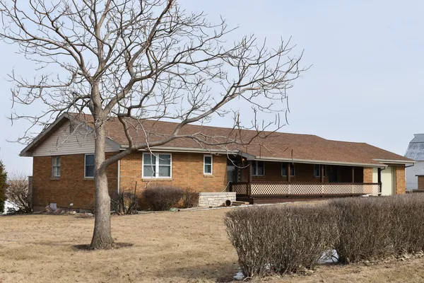 a front view of a house with a tree