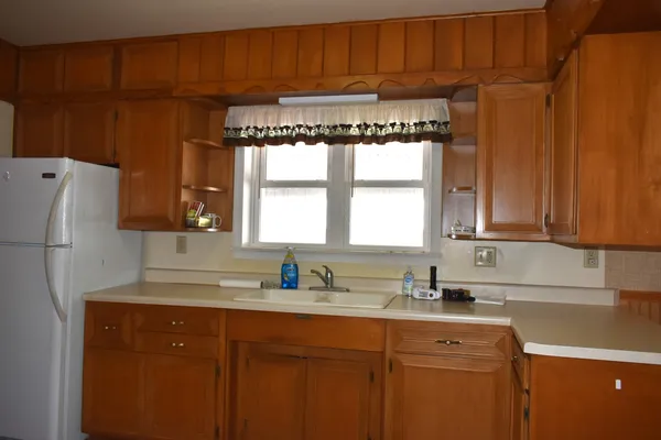a kitchen with granite countertop a refrigerator and a sink