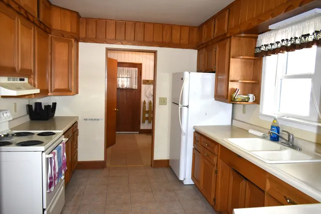 a kitchen with granite countertop a refrigerator and a sink